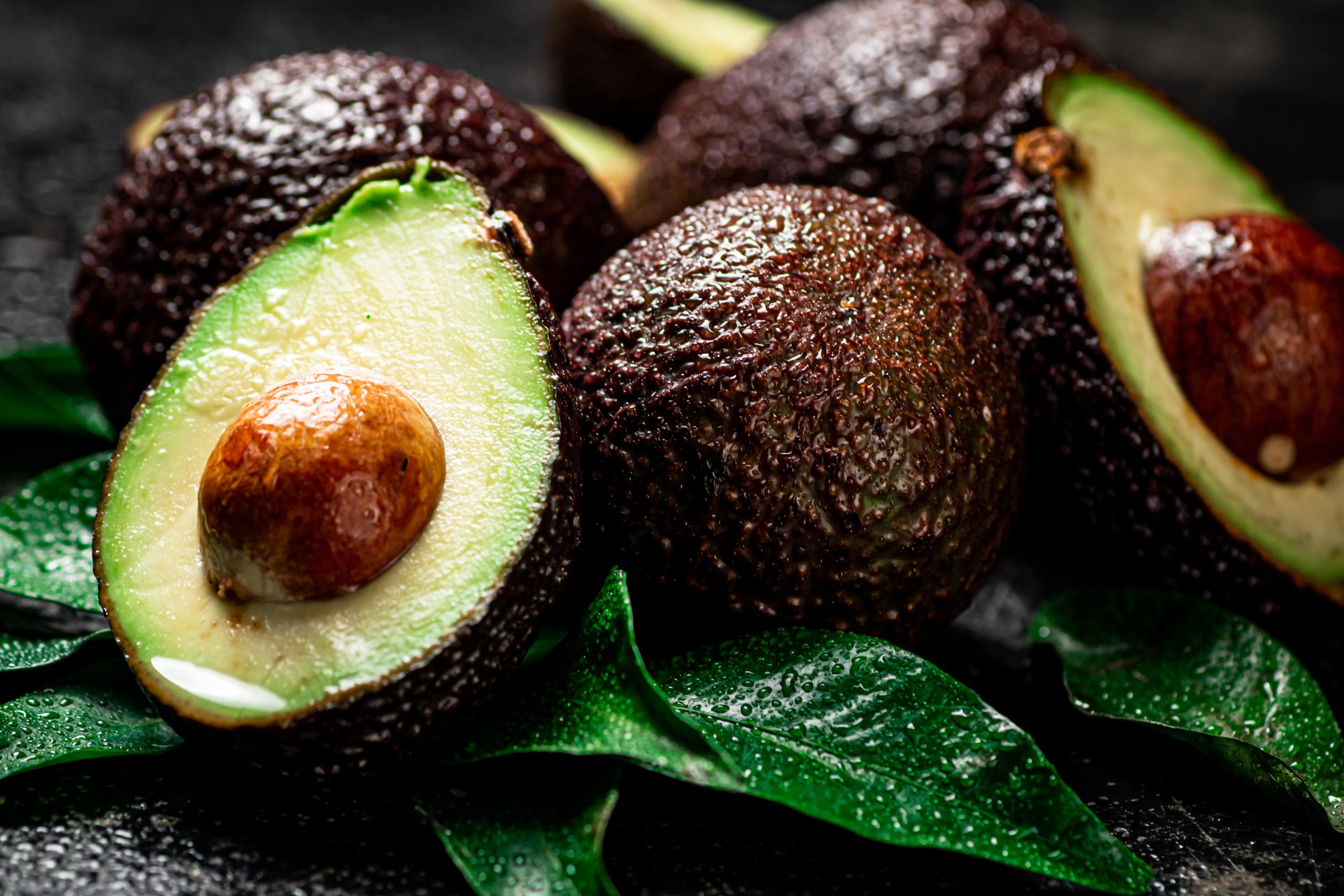 fresh-avocado-with-leaves-on-a-black-background-2024-09-12-23-28-45-utc-min